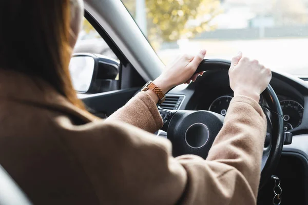 Recadrée de femme conduisant une voiture au premier plan flou — Photo de stock