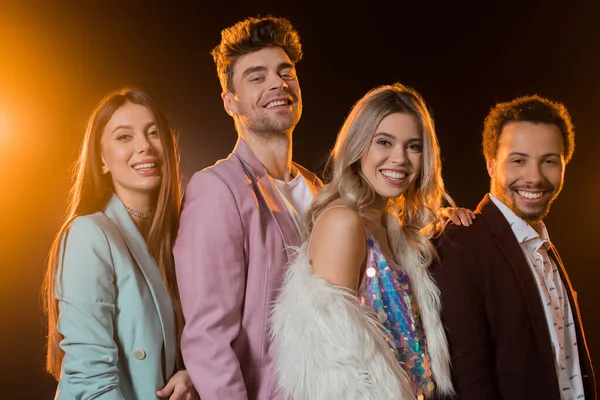 Grupo de amigos multiculturales felices sonriendo en negro - foto de stock