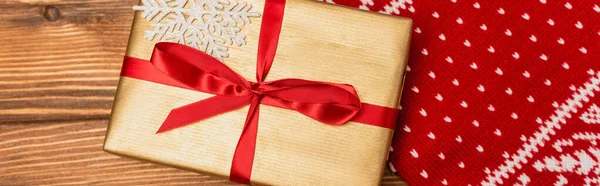 Vue du haut de la boîte cadeau et écharpe tricotée rouge sur fond en bois, bannière — Photo de stock