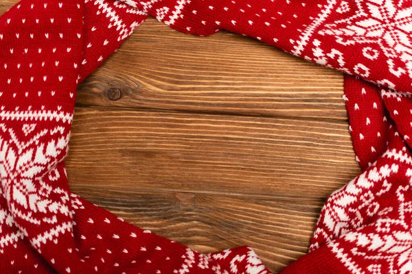 Vue de dessus de l'hiver écharpe tricotée rouge sur fond en bois — Photo de stock