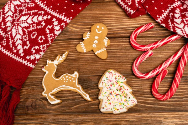 Vue de dessus des biscuits de pain d'épice d'hiver et écharpe sur fond en bois — Photo de stock