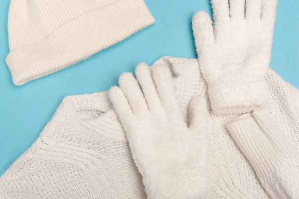 Vue de dessus des tricots blancs d'hiver sur fond bleu — Photo de stock