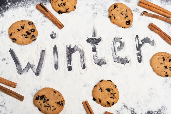 Top view of word winter and chocolate cookies on black background — Stock Photo