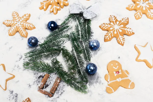 Top view of Christmas tree and gingerbread cookies on snow — Stock Photo