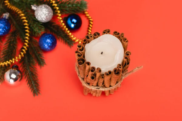 Vista superior da árvore de Natal decorada e vela no fundo vermelho — Fotografia de Stock