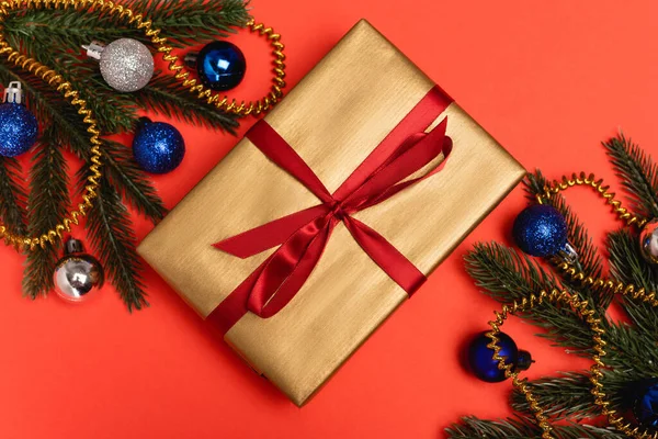 Vue du dessus de l'arbre de Noël décoré et cadeau sur fond rouge — Photo de stock