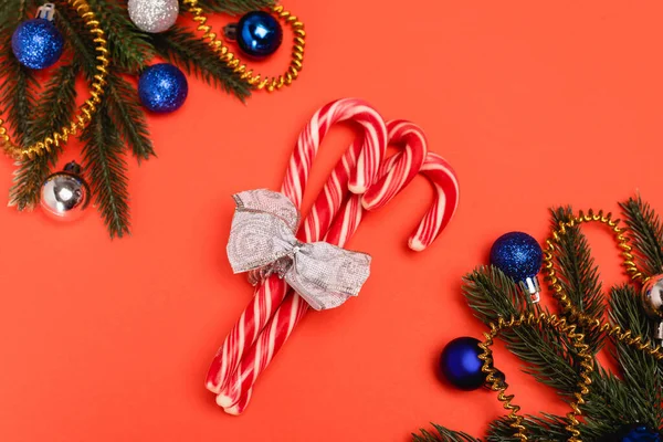 Vue de dessus du sapin de Noël décoré et des cannes à bonbons sur fond rouge — Photo de stock