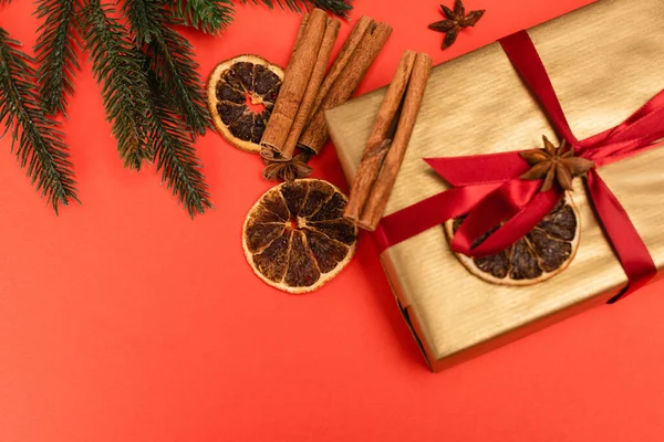 Vue du dessus de l'arbre de Noël, cadeau avec des épices sur fond rouge — Photo de stock