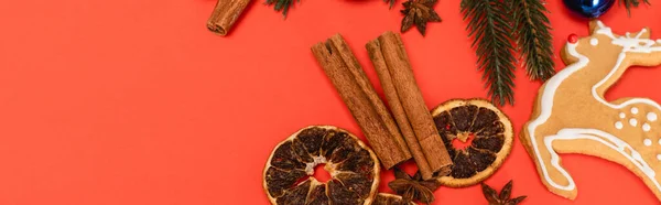 Top view of Christmas tree, spices and gingerbread cookie on red background, banner — Stock Photo