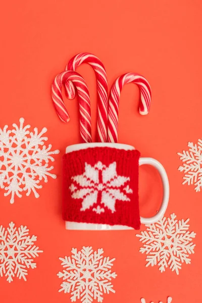 Top view of candy canes, snowflakes and mug on red background — Stock Photo