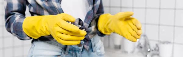 Cropped view of woman in rubber gloves standing in bathroom, banner — Stock Photo