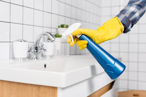 Vista ritagliata della donna in guanto di gomma utilizzando detergente sul lavandino in bagno — Foto stock