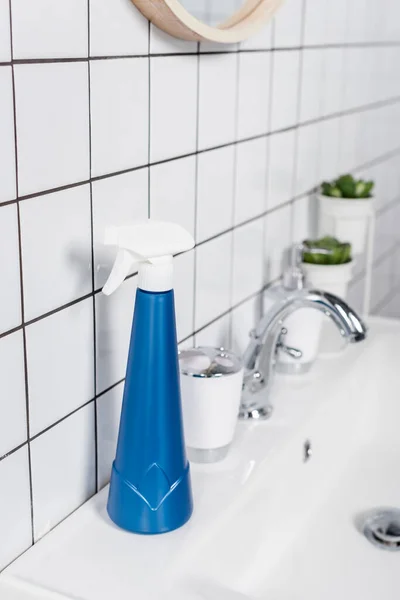 Bottle of detergent with sprayer on sink in bathroom — Stock Photo