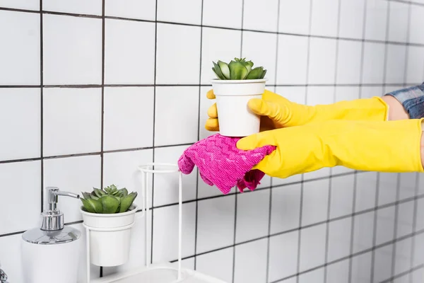 Vista recortada de mujer en planta de limpieza de guantes de goma con trapo en baño moderno - foto de stock