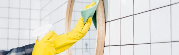 Vista recortada de la mujer en guantes de goma espejo de limpieza con trapo y detergente en el baño, pancarta - foto de stock