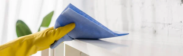 Cropped view of hand in yellow rubber glove cleaning cupboard with rag, banner — Stock Photo