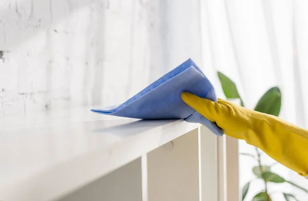 Vista ritagliata di persona in guanto di gomma armadio di pulizia con straccio a casa — Foto stock