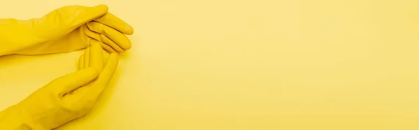 Vista superior de las manos en guantes de goma sobre fondo amarillo, banner — Stock Photo