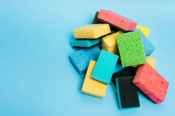 Top view of colorful sponges on blue background — Stock Photo