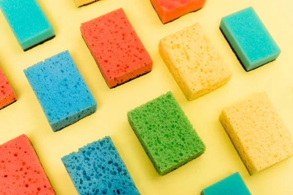 High angle view of colorful sponges on yellow background — Stock Photo