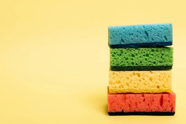 Close up view of colorful sponges on yellow background — Stock Photo