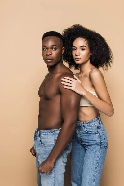 African american couple in jeans looking at camera isolated on beige — Stock Photo