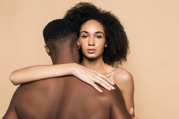 Encaracolado afro-americano mulher abraçando namorado isolado no bege — Fotografia de Stock