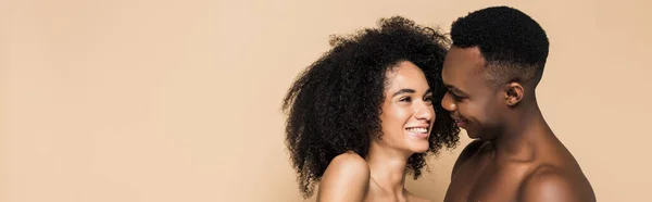 Feliz mulher afro-americana rindo com namorado alegre isolado no bege, bandeira — Fotografia de Stock