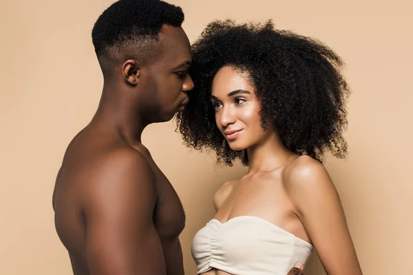 Sem camisa afro-americano homem olhando para mulher encaracolado no topo isolado no bege — Fotografia de Stock