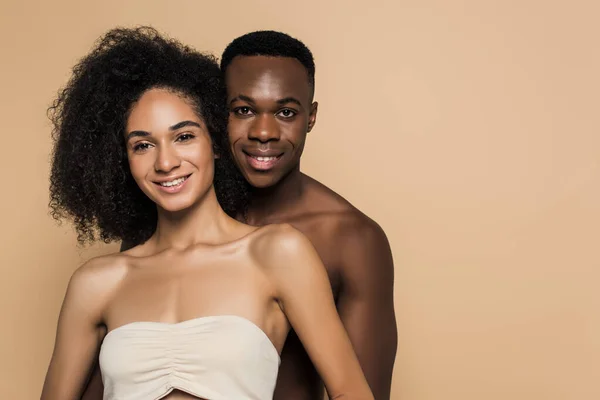 Feliz africano americano mujer y hombre sonriendo aislado en beige - foto de stock