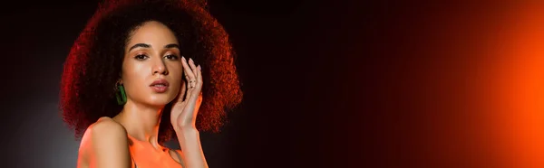 Curly african american woman looking at camera on black, banner — Stock Photo