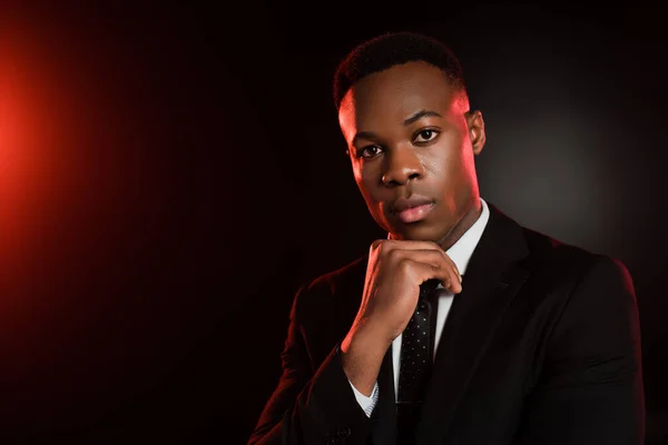 African american man in formal wear looking at camera on black — Stock Photo