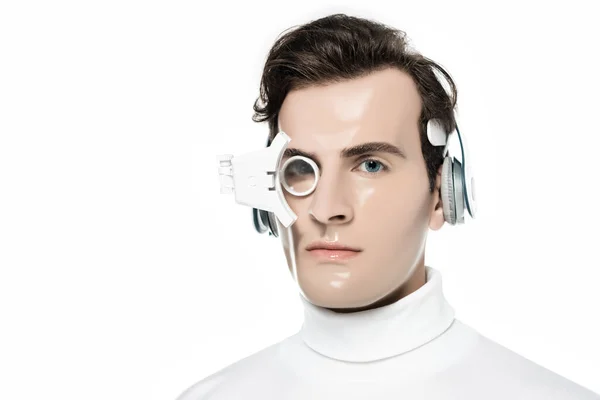 Morena cyborg hombre en auriculares y lente para los ojos mirando a la cámara aislada en blanco - foto de stock