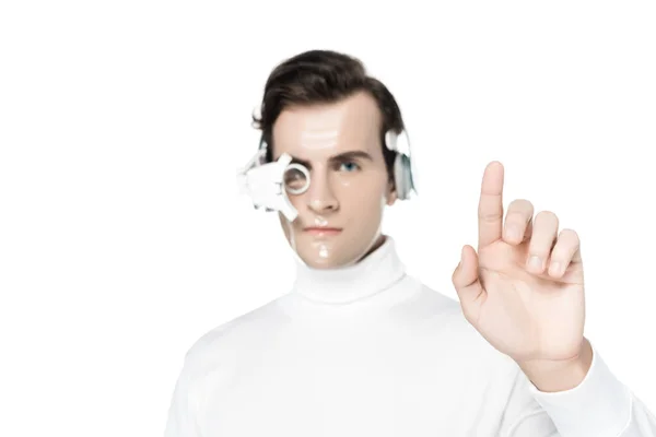 Cyborg en lente de ojo digital y auriculares sobre fondo borroso apuntando con el dedo aislado en blanco - foto de stock