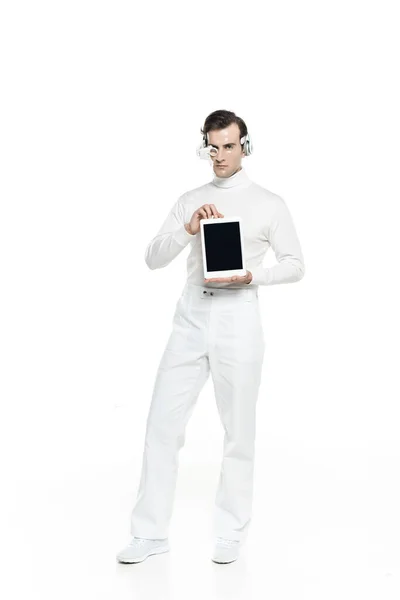 Кіборг у навушниках та окулярах тримає цифровий планшет з порожнім екраном на білому тлі — стокове фото