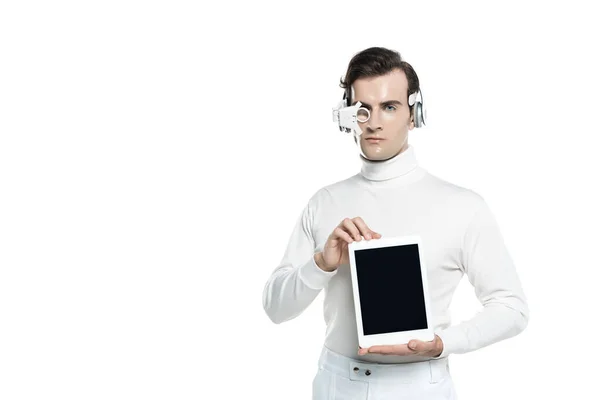 Cyborg man in digital eye lens and headphones showing digital tablet with blank screen isolated on white — Stock Photo