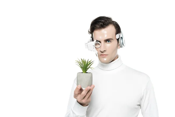 Cyborg in eye lens and headphones holding pot with plant isolated on white — Stock Photo