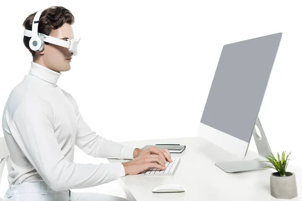 Cyborg in Kopfhörer und digitale Augenlinse mit Computer mit leerem Bildschirm in der Nähe von Notebook und Pflanze auf unscharfem Vordergrund isoliert auf weiß — Stockfoto