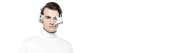 Cyborg man in headphones and eye lens looking at camera isolated on white with copy space, banner — Stock Photo