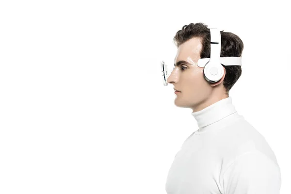 Cyborg en auriculares y lente de ojo digital mirando hacia otro lado aislado en blanco - foto de stock