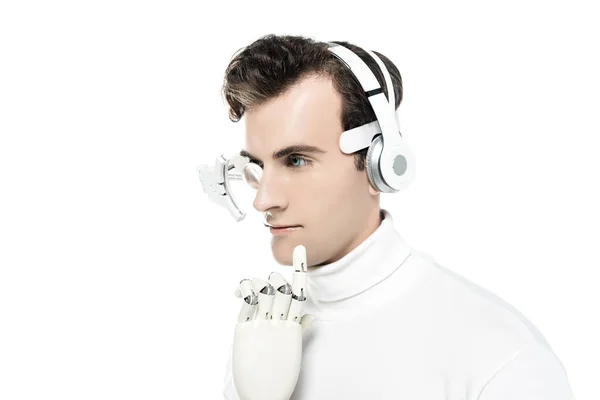 Cyborg con auriculares, lente de ojo digital y mano artificial mirando hacia otro lado aislado en blanco - foto de stock