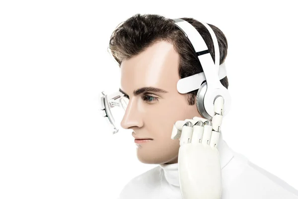 Cyborg in eye lens touching headphones with artificial hand isolated on white — Stock Photo