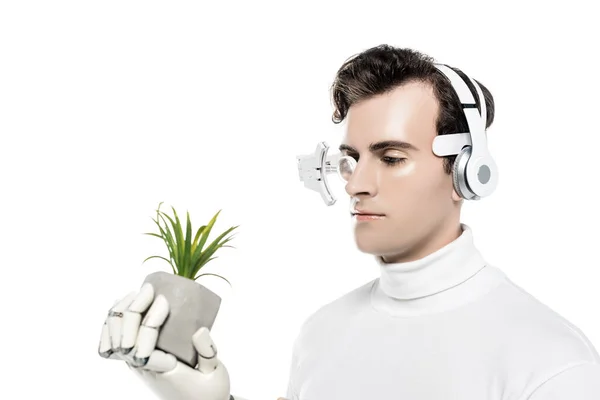 Cyborg in headphones and digital lens holding plant in artificial hand isolated on white — Stock Photo