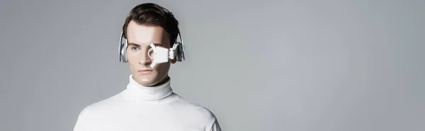 Cyborg in digitaler Augenlinse und Kopfhörer isoliert auf grau mit Kopierraum, Banner — Stockfoto