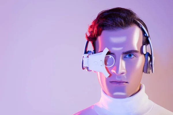 Portrait de cyborg en casque et lentille oculaire numérique sur fond violet — Photo de stock