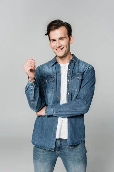 Homme joyeux en jean veste regardant caméra isolée sur gris — Photo de stock