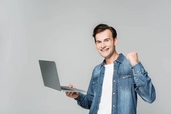 Lächelnder Mann mit Laptop zeigt Yah-Geste isoliert auf grau — Stockfoto