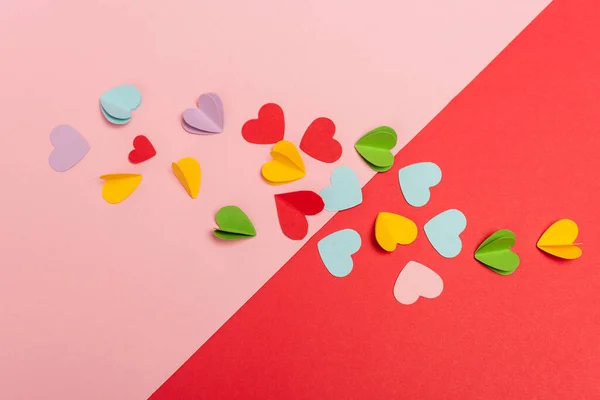 Top view of colorful paper hearts on red and pink background — Stock Photo