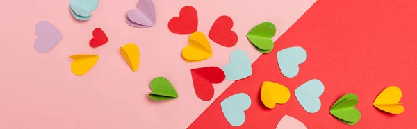 Top view of colorful paper hearts on red and pink background, banner — Stock Photo