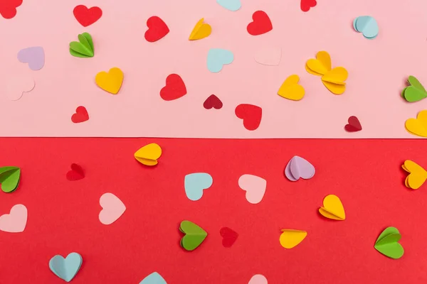 Vue du haut des coeurs en papier coloré sur fond rouge et rose — Photo de stock